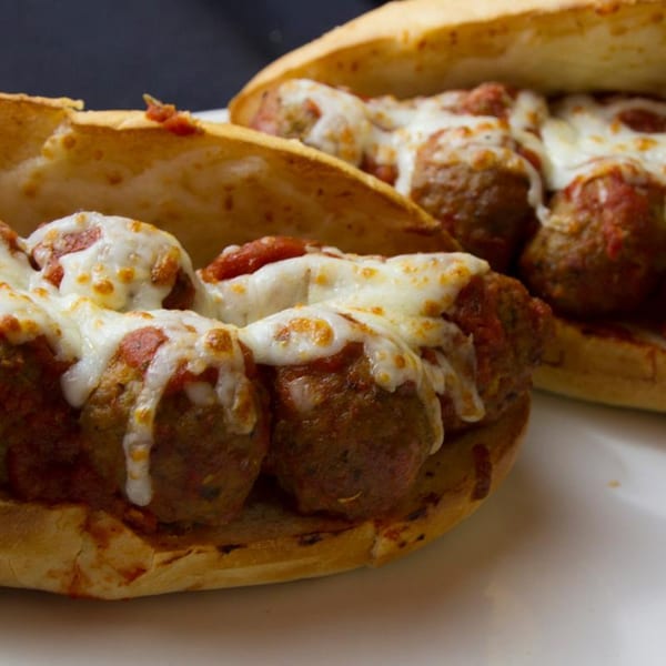 Two meatball subs from Wasatch Pizza, topped with melted cheese and marinara sauce.